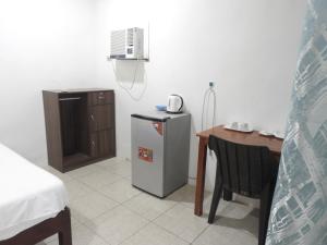 a room with a table and a refrigerator and a desk at Pacifico Seaside Lodge in Moalboal
