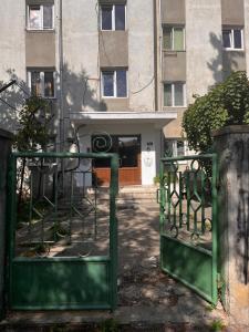 a green gate in front of a building at Mimosa Studio in Cluj-Napoca