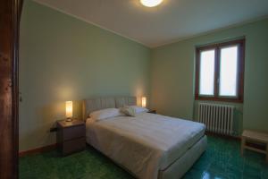 sypialnia z białym łóżkiem i 2 lampami w obiekcie Villa Olivee w mieście Bellagio