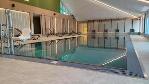 a large swimming pool with chairs in a building at ALPINE Appartement 208 Schladming by globboard in Schladming