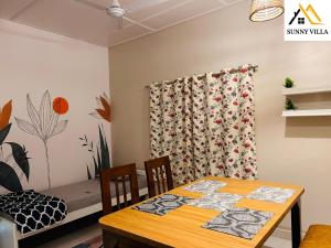 a dining room with a table and a bed at Sunny Villa in Sibsāgar