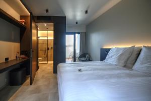 a bedroom with a large white bed and a bathroom at Hotel Hallensis in Halle