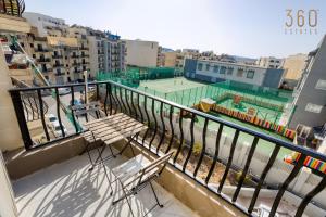 a balcony with a bench and a tennis court at Stylish 3BR Apt with panoramic balcony in Qawra by 360 Estates in St Paul's Bay