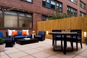 Un patio con sofás y una mesa y sillas. en The Gardens Sonesta ES Suites New York, en Nueva York