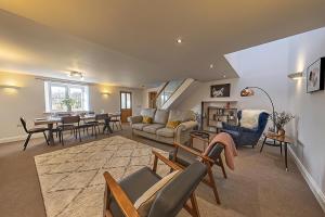 a living room with a couch and a table at Stunning Barn Conversion with HOT TUB and ALPACAS - Ty Cerrig Barn in Corwen