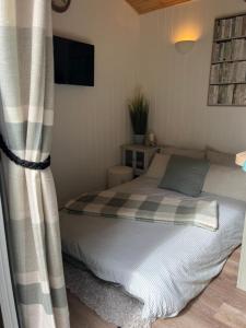 a bed in a room with a curtain and a bed sidx sidx sidx at Shetland Retreat in Three Legged Cross