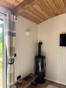 a living room with a wood stove and a table at Shetland Retreat in Three Legged Cross