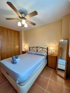 Un dormitorio con una cama y un ventilador de techo. en Adosado en urbanización encantadora, en Oropesa del Mar