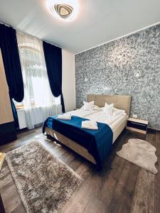 a bedroom with a bed with a blue blanket at Casa Mugur in Sinaia