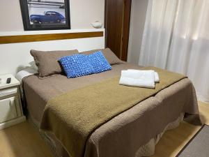 a bed with two pillows on it in a room at Pousada dos Pássaros in Gramado