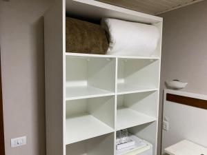 a closet with white shelves and a pillow at Pousada dos Pássaros in Gramado