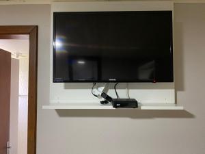 a flat screen tv hanging on a wall at Pousada dos Pássaros in Gramado
