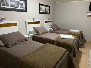 a room with three beds in a room at Pousada dos Pássaros in Gramado