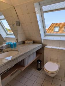 ヴィーク・アウフ・リューゲンにあるFerienwohnung An de Waterkant Wiekのトイレ、洗面台、窓のあるバスルーム