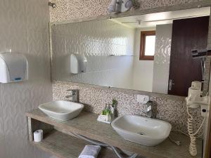 a bathroom with a sink and a mirror at Pousada dos Pássaros in Gramado