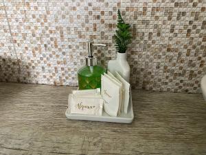a bathroom counter with a bottle of perfume and books at Pousada dos Pássaros in Gramado