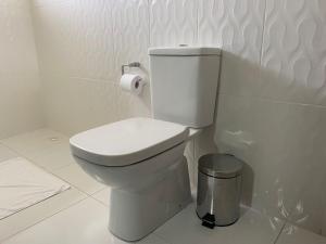 a white toilet in a bathroom with a roll of toilet paper at Pousada dos Pássaros in Gramado