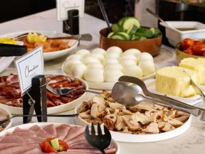 ein Buffet mit verschiedenen Speisen auf einem Tisch in der Unterkunft Mercure Paris Saint-Ouen in Saint-Ouen