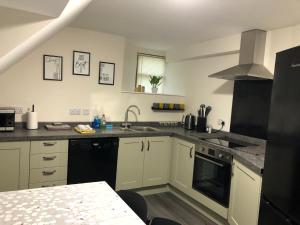 a kitchen with white cabinets and a black appliances at The Three Kings Inn in Cullen