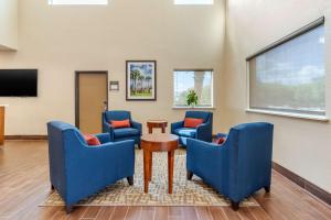 a waiting room with blue chairs and a screen at Comfort Suites San Antonio Airport North in San Antonio