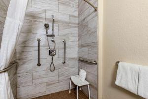 a bathroom with a shower with a toilet and a stool at Comfort Suites San Antonio Airport North in San Antonio