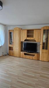 un soggiorno con armadi in legno e TV a schermo piatto di Eichhörnchen-Haus Körner im Schwarzwald a Peterzell