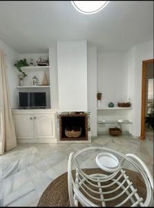 a living room with a fireplace and a tv at Apto Laguna con piscina in El Portil +21 photos