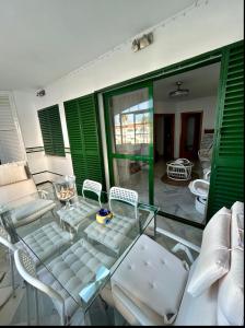 a patio with a glass table and chairs on a balcony at Apto Laguna con piscina in El Portil