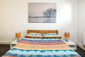 a bedroom with a bed with two lamps on two tables at Hoxton Rooms in London