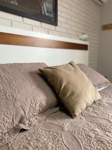 a bed with a pillow on top of it at Pousada dos Pássaros in Gramado