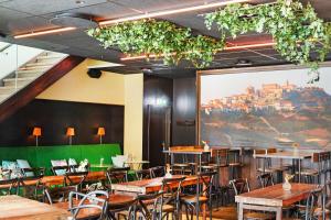 a restaurant with tables and chairs and a large painting at Best Western Plus Park City Solna in Solna