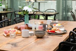 a wooden table with breakfast foods on it at Best Western Plus Park City Solna in Solna