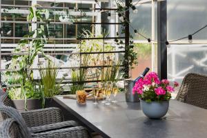 a patio with a table with flowers and plants at Best Western Plus Park City Solna in Solna