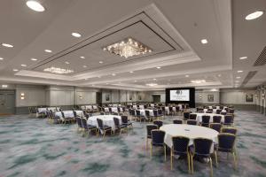 a banquet hall with tables and chairs and a screen at DoubleTree By Hilton Brighton Metropole in Brighton & Hove +37 photos