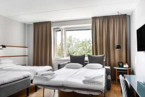 a hotel room with two beds and a window at Best Western Plus Park City Solna in Solna