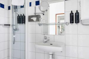 a white bathroom with a sink and a mirror at Best Western Plus Park City Solna in Solna