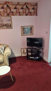 a living room with a couch and a flat screen tv at Apartment 3 in Leicester