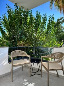 two chairs and a table on a balcony with trees at Leos Apartments Apart3 in Side