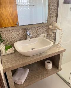 a bathroom with a sink and a mirror at Pousada dos Pássaros in Gramado