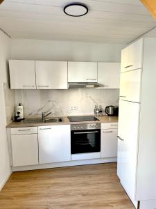 a white kitchen with white cabinets and a sink at Casita am Baldinger Tor in Nördlingen