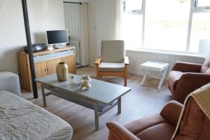 a living room with a couch and a coffee table at Kustverhuur, Huuske Groede, pittoresk huisje vlakbij zee in Groede