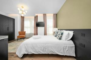 a bedroom with a large white bed and a chair at Nine Elms City Suites in London