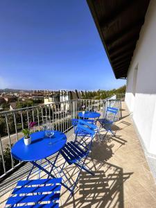un patio con tavoli e sedie blu sul balcone di La Finestra Blu Alba 1 ad Alba