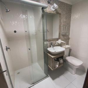 a bathroom with a shower and a toilet and a sink at Pousada dos Pássaros in Gramado
