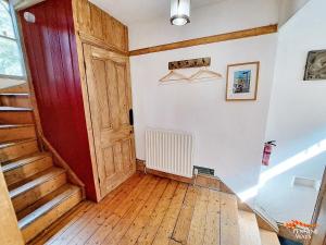 an empty room with a red door and wooden floors at Market House Apartment - Dog Friendly in Alston