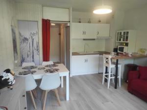 a kitchen and living room with a table and chairs at Studio cabine résidence du Stade in Saint-Lary-Soulan