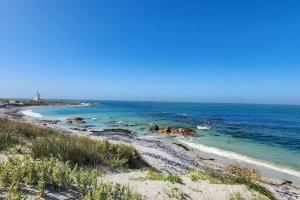 a beach with the ocean and a lighthouse in the background at 10 Seaview Close, Shelley Point in St Helena Bay