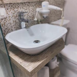 a white sink on a wooden counter in a bathroom at Pousada dos Pássaros in Gramado