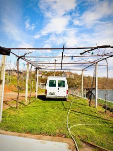 a white van parked under a metal structure at Villa Ndoj Bukmire in Rrëshen