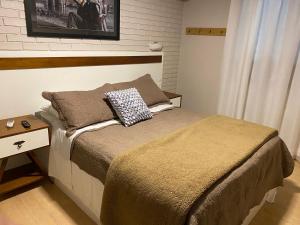 a bedroom with a bed and a nightstand with a bed sidx sidx at Pousada dos Pássaros in Gramado